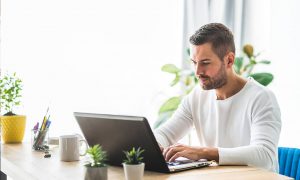 A man searching on a laptop who found a law firm due to search engine optimization for estate & probate lawyers